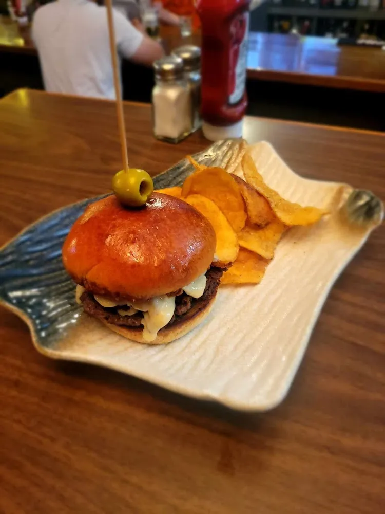 Wagyu Smash Burger Infused with Fried Onions with a 5 Cheese Sauce and Served with Chips